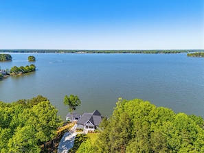 Una propiedad junto al lago con una casa, un muelle y un bote.