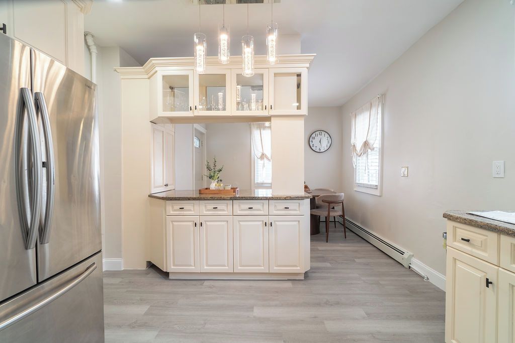 A kitchen with a central island, stainless steel appliances, and pendant lighting.