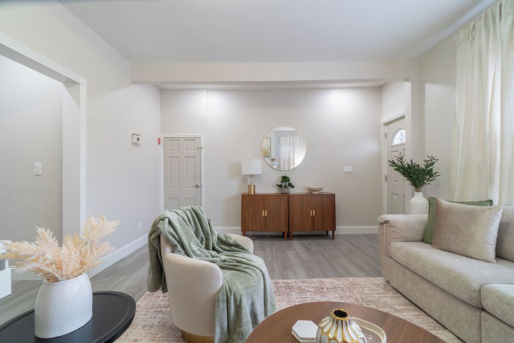 A living room with a sofa, armchair, coffee table, and a cabinet.