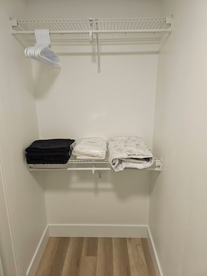 A closet with a hanging rack, shelves, and a folded clothes rack. - Chester Luxury Suites - Brand New Moncton Getaway (Moncton)