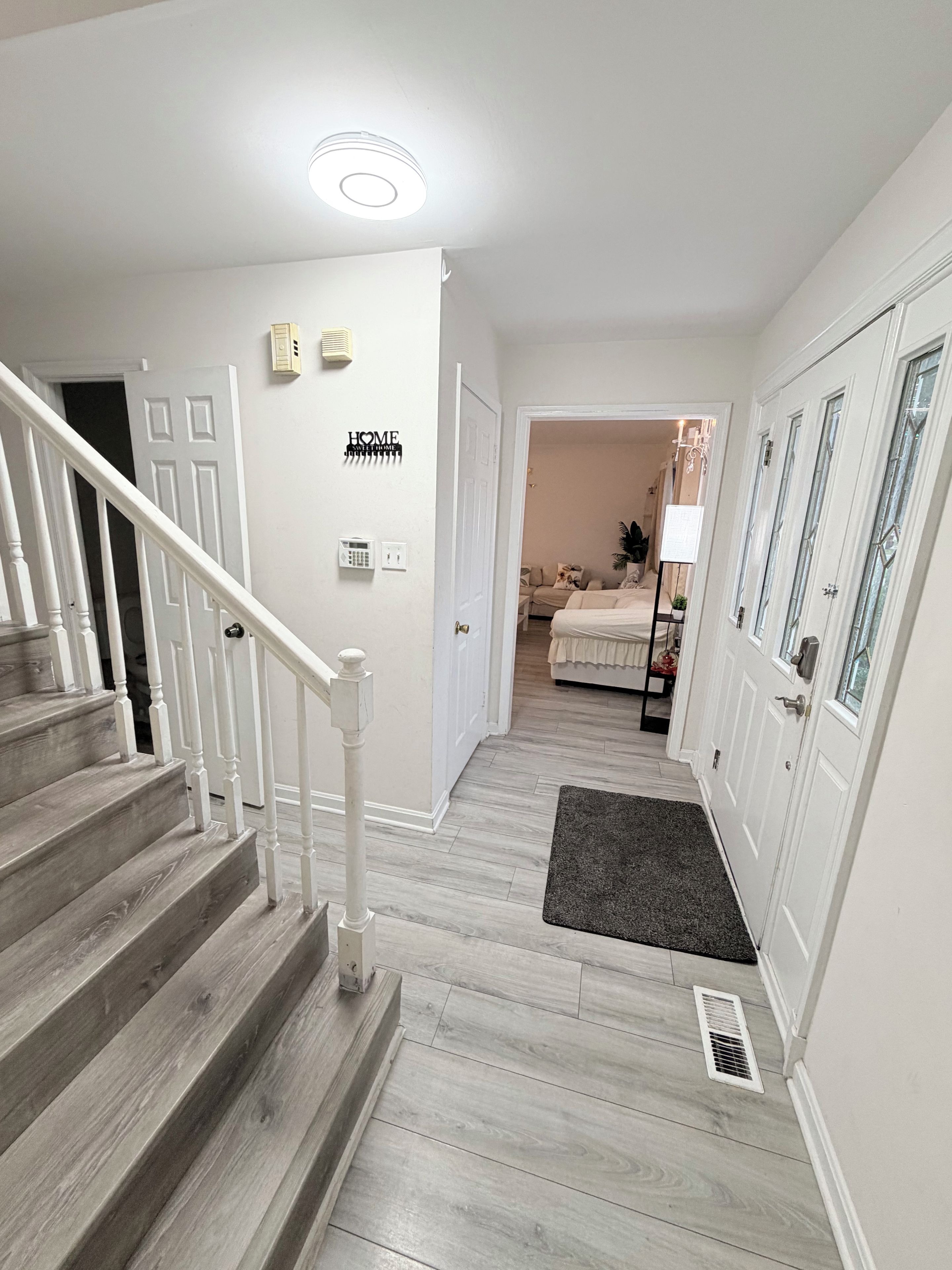 A staircase leading to a bedroom with a bed, a bedside table, and a lamp.