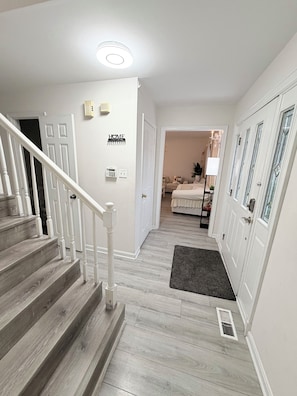 A staircase leading to a bedroom with a bed, a bedside table, and a lamp.