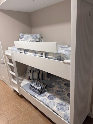 Un lit superposé composé d’un lit inférieur et d’un lit supérieur, tous deux dotés de draps à motifs.