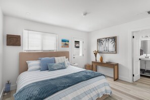 A bedroom with a bed, bedside table, and a painting on the wall. - Brand new!! Water front home in serene Dania Beach. Located near airport. (Dania Beach)