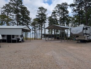 Um camping com veículos recreativos, uma área de piquenique coberta e um edifício com a inscrição 'RIVER'.