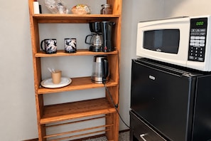 A kitchenette with a microwave, coffee maker, and a shelf with mugs and a cup. - Clarkdale Suite Mingus Mountain Verde Valley Views (Clarkdale)