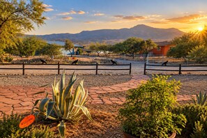 A landscaped area with a paved walkway, a welcome sign, and a fenced enclosure with birds. - Clarkdale Suite Mingus Mountain Verde Valley Views (Clarkdale)