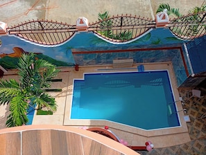 A swimming pool with a decorative roof and a view of the surrounding area.