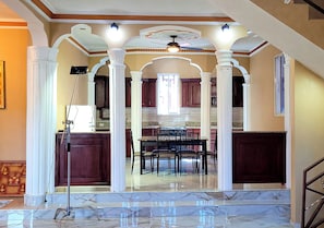 A spacious interior with a dining area, kitchen, and a staircase leading to an upper level.