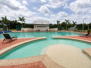 A swimming pool with lounge chairs and a building in the background. - Casa Lamay | Clubhouse with a pool, internet, and a beach just a 15-minute drive away (Chuburná)