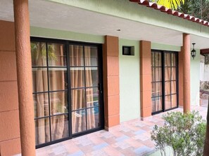 A building with large windows, a tiled floor, and a small plant in the foreground.