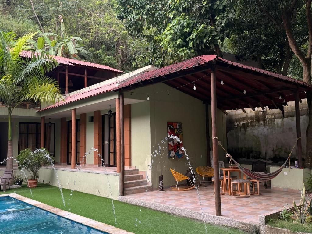 A house with a swimming pool, a covered patio with a hammock, and a small garden.