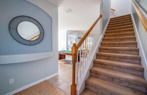 Un escalier avec des rampes en bois menant à l’étage supérieur.