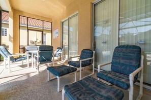 A sunlit room with a glass door, a table, and several chairs with cushions. - LUXURY ORLANDO VACATION HOME PRIVATE HEATED POOL SLEEPS 11 NEAR DISNEY&UNIVERSAL (Davenport)