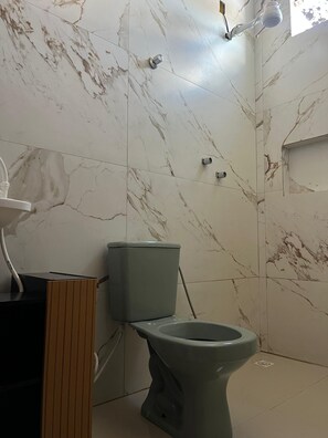 Un baño con inodoro, lavabo y ducha.
