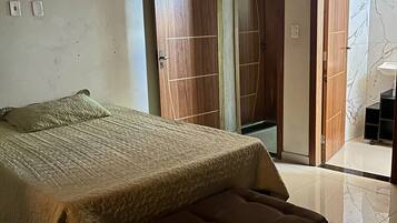 Ein Schlafzimmer mit einem Bett, einer Bank, einem Kleiderschrank und einem Badezimmer mit Marmorboden.