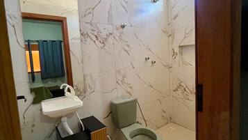 Ein Badezimmer mit Marmorboden, Waschbecken, Toilette und Spiegel.