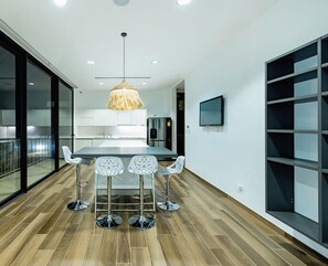 A modern kitchen with a central island, bar stools, and a hanging light fixture. - Luxury Villa With Private Beach Access (Pinilla)
