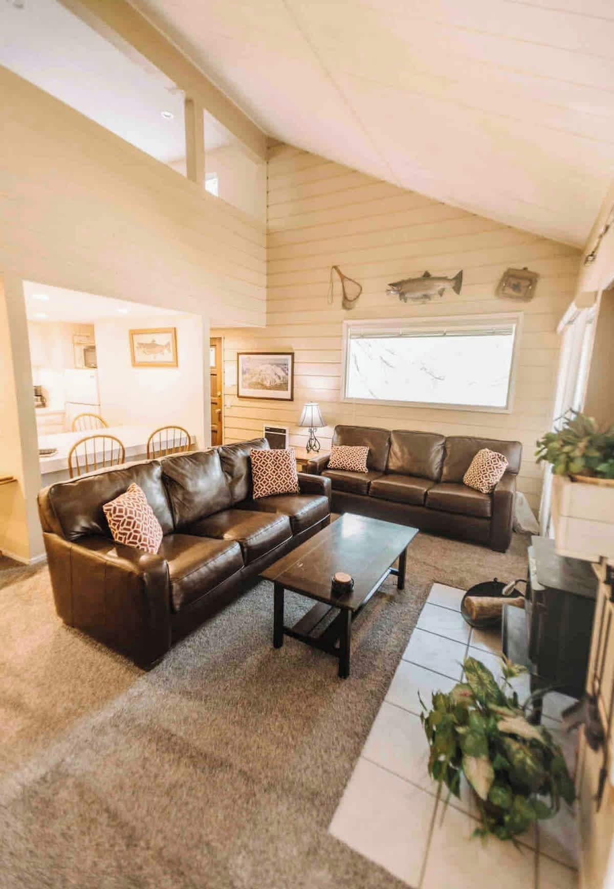 A spacious living room with a sectional sofa, a coffee table, and a large window.