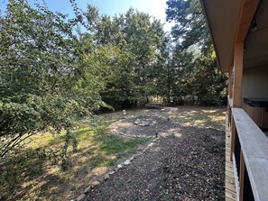 Un jardin avec une terrasse en bois, un chemin de pierres et une table de pique-nique.