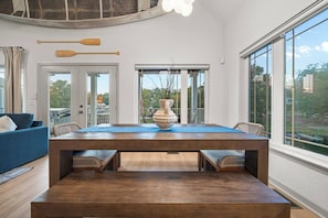 A dining area with a wooden table, chairs, and a vase centerpiece. - 3 Lakefront Homes | Pools | Game Rooms | Sleeps 36 (Hot Springs)
