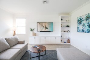 A modern living room with a sofa, coffee table, and a white cabinet with shelves. - Sarasota National Golf Villa - 2BR+Den, 2 Golf Memberships, Clubhouse Amenities (Venice)
