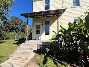 A two-story house with a front porch, a visible staircase, and a fenced yard. - Historic Two Bedroom Apartment Overlooking Olde Towne Daphne (Daphne)