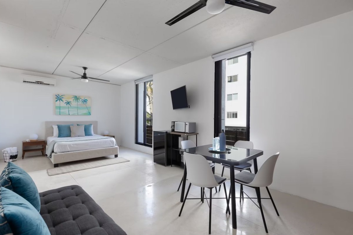 A modern bedroom with a bed, bedside table, and a ceiling fan.