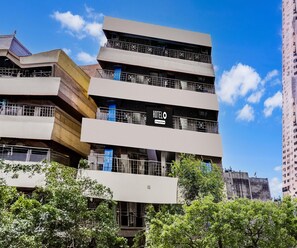 Un hotel de varios pisos con un diseño arquitectónico moderno, con balcones y un letrero grande que dice 'HOTEL' en la fachada.