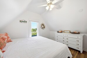 A bedroom with a bed, a dresser, a ceiling fan, and a view of the outdoors. - Perfect Family Beach Getaway (Old Orchard Beach)