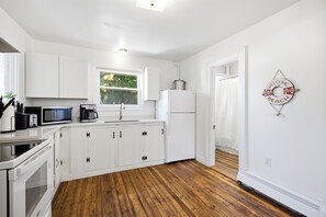 A kitchen with white cabinets, a refrigerator, a microwave, and a coffee maker. - Perfect Family Beach Getaway (Old Orchard Beach)