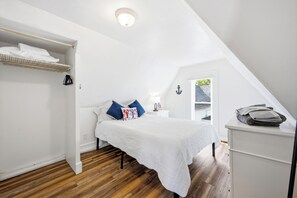 A bedroom with a bed, a nightstand, a lamp, and a window. - Perfect Family Beach Getaway (Old Orchard Beach)