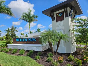 A golf and country club sign with palm trees and a clear sky. - Luxury Vacation Townhome in Wellen Park Golf & Country Club (Venice)