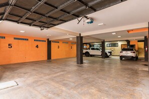 Eine mehrstöckige Parkgarage mit nummerierten Parkfeldern, ein weißer Pritschenwagen und ein weißer SUV.