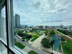 A cityscape with modern buildings, a park with pathways, and a river. - Cozy 3 Beds Suite (Toronto)