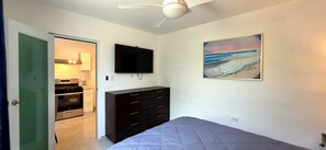 A bedroom with a bed, a dresser, a television, and a painting. - Private 2BD/2BA Rear Casita in Guaynabo (Guaynabo)