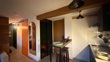 A compact kitchen with a wooden countertop, a laptop, and a sink.