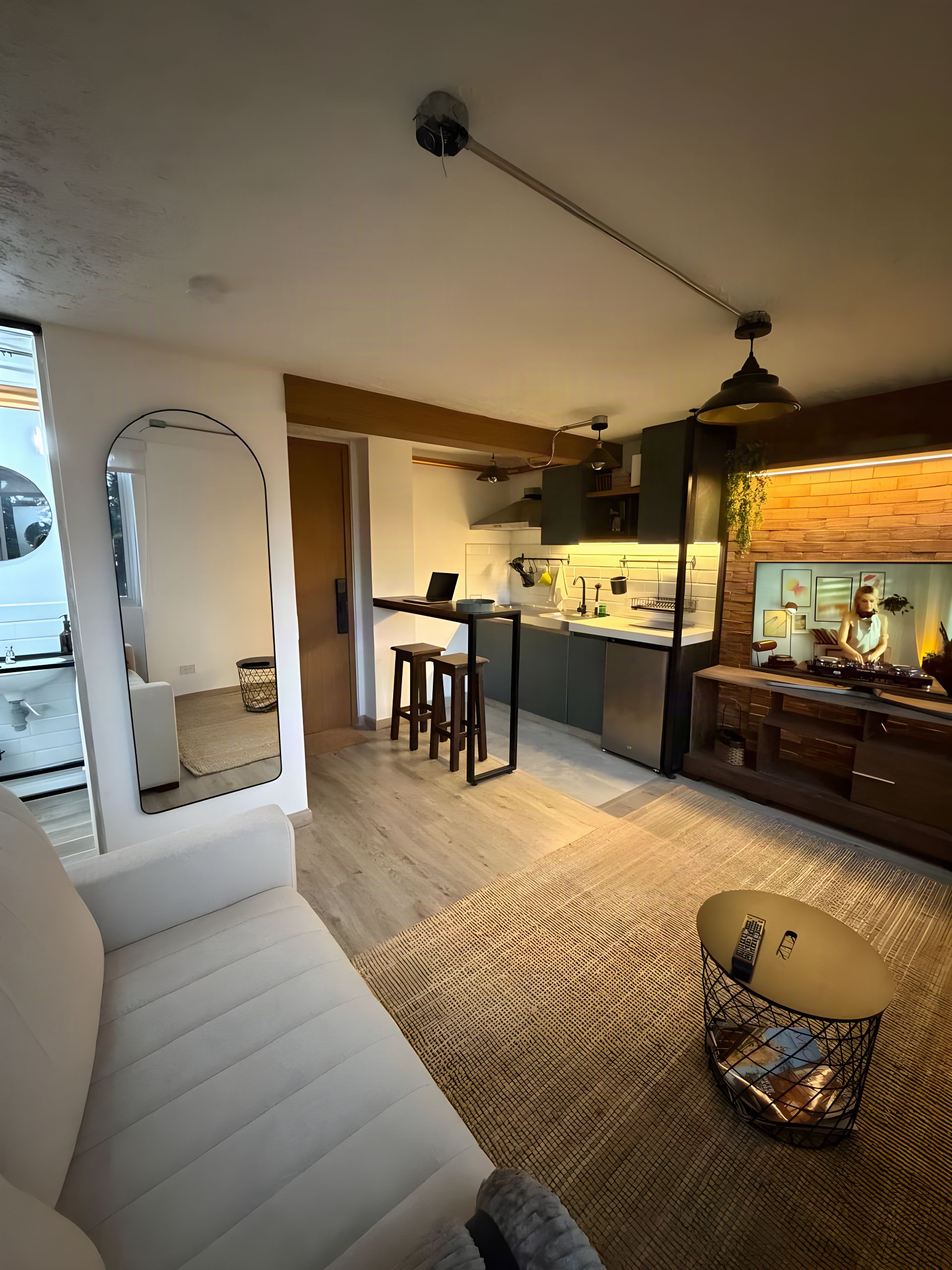 A modern living room with a sofa, a coffee table, and a kitchen area with a bar.