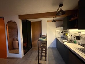 Una cocina moderna con un taburete de bar, un lavamanos y un colgante.