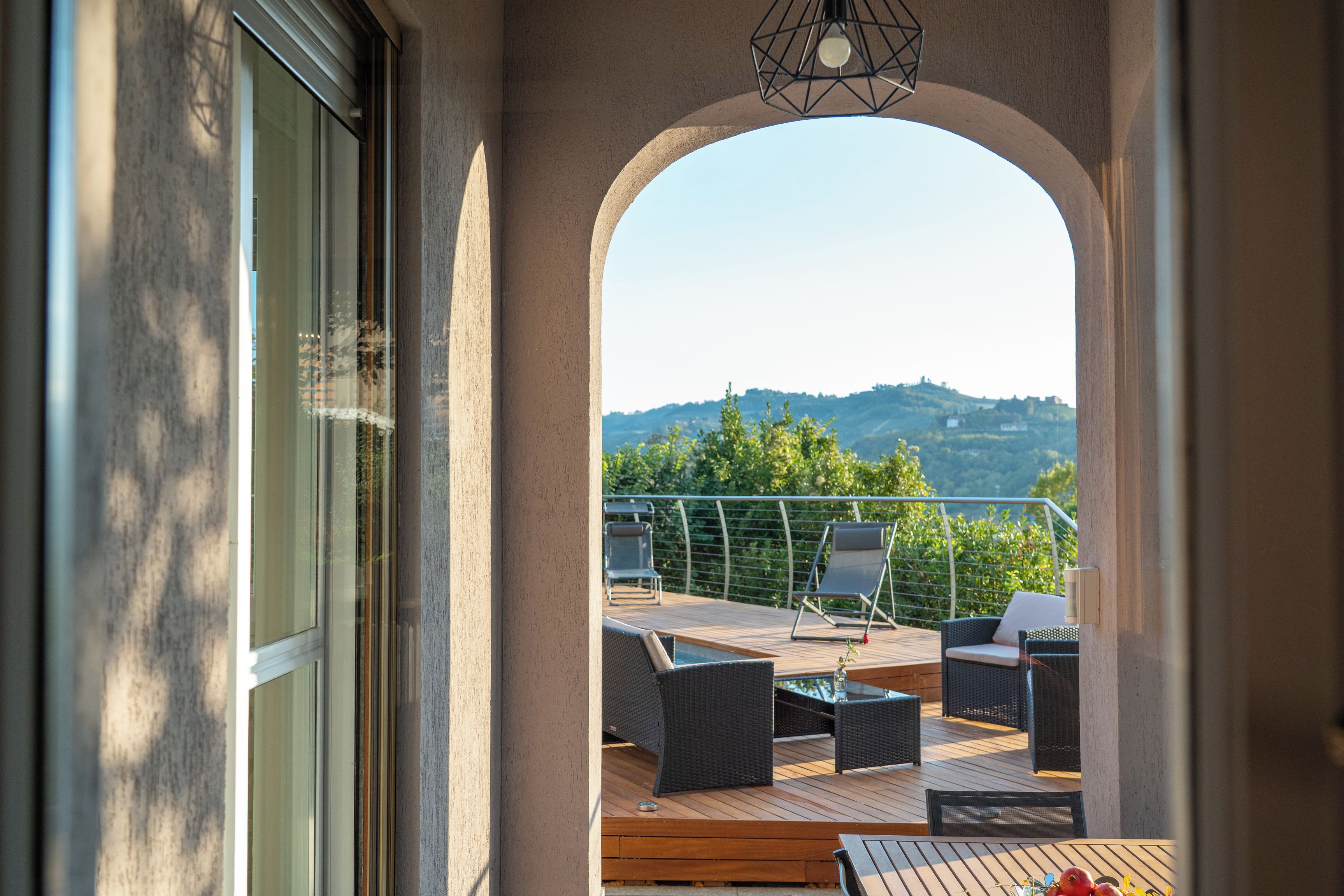 Un balcone con mobili da esterno, vista sul paesaggio e cielo sereno.