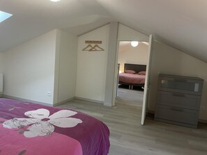 A bedroom with a bed, a dresser, and a closet. - Le Gîte de l'Abbaye - FONTAINE LE COMTE (FONTAINE LE COMTE)