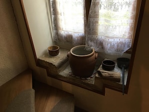 A rustic interior with a window sill holding pottery and a small table. - La Boulitte - ASNOIS (ASNOIS)