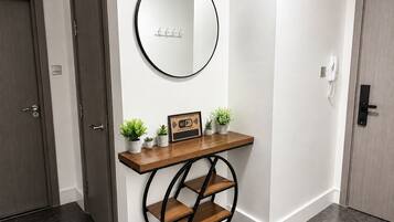 A hallway with a wooden console table, a round mirror, and a small potted plant.