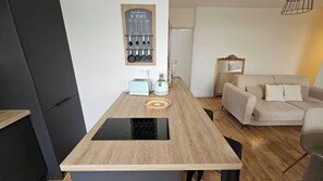Eine moderne Küche mit Holzarbeitsplatte, integriertem Induktionskochfeld und einer Wandhalterung für Küchenutensilien.