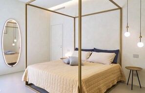 A modern bedroom with a four-poster bed, a round mirror, bedside tables, and pendant lighting. - MiCasa Jacuzzi & Rooftop SicilyMyHome (Noto)