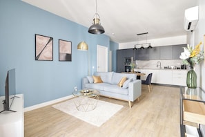 A modern living room with a sofa, coffee table, and artwork on the wall. - Prestige stay with les Halles view, A/C (Béziers)