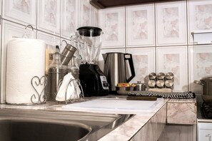 Eine Küche mit Spüle, Mixer, Wasserkocher und Kaffeemaschine.
