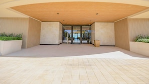 A modern building entrance with a curved wooden ceiling, glass doors, and tiled flooring. - Penthouse with Ocean Views and Infinity Pool (Nassau)