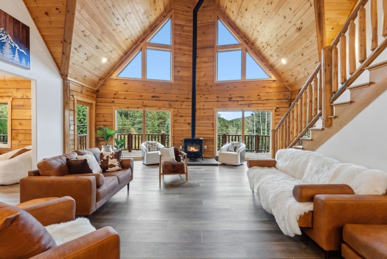 Il s'agit d'une pièce spacieuse de style loft, dotée d'un plafond haut, de poutres en bois et d'une cheminée. On y trouve plusieurs coins salon avec des canapés et des fauteuils en cuir.
