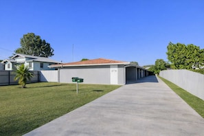 A single-story building with a numbered mailbox, a concrete driveway, and a fenced yard. - Convenient Townsville Stay Near Hospital and CBD (Pimlico)